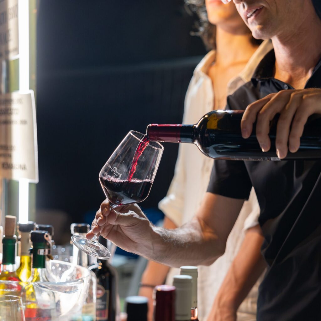 Sommelier che versa vino rosso al banco di degustazione