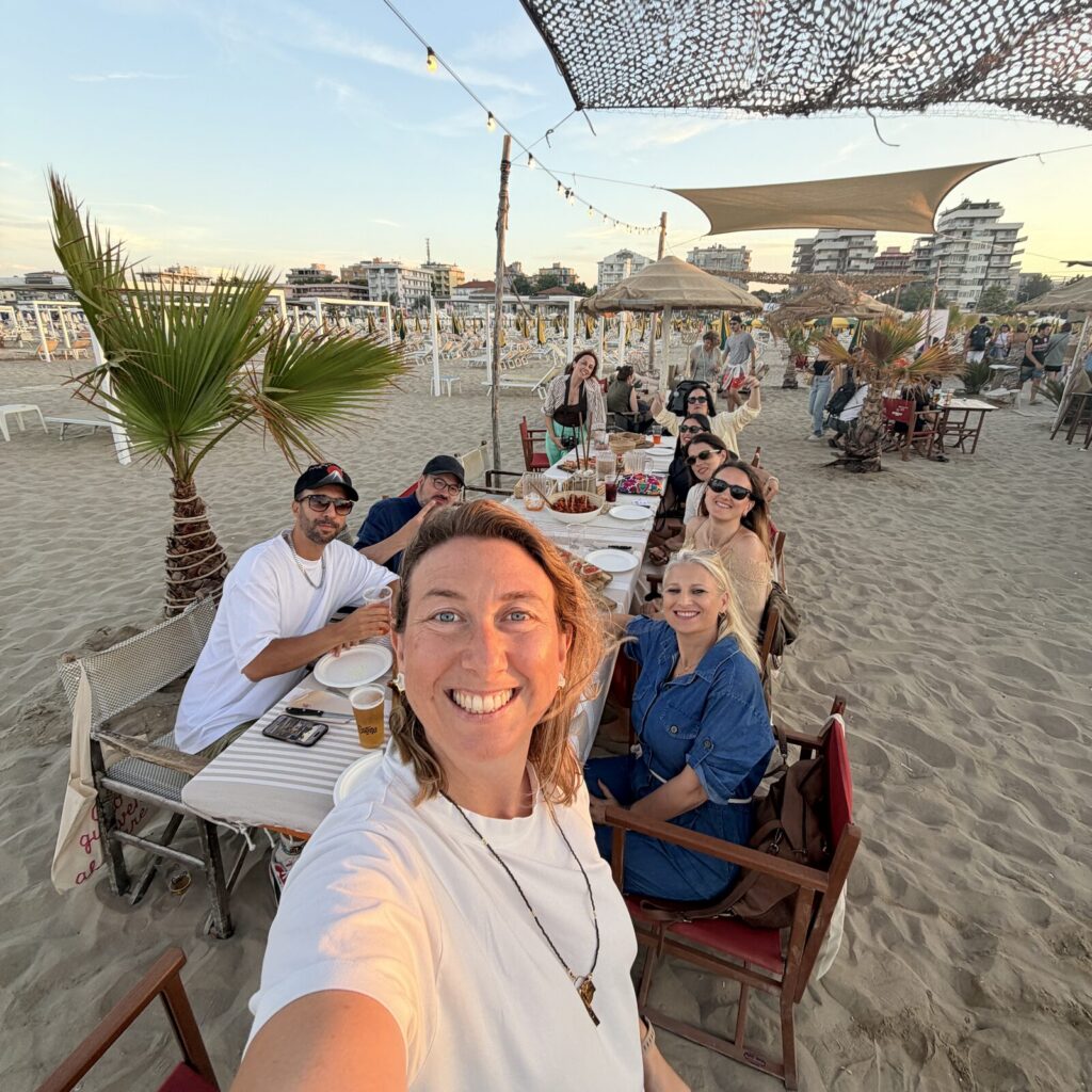 Il team di Spuma sorride durante una cena in spiaggia a Rimini
