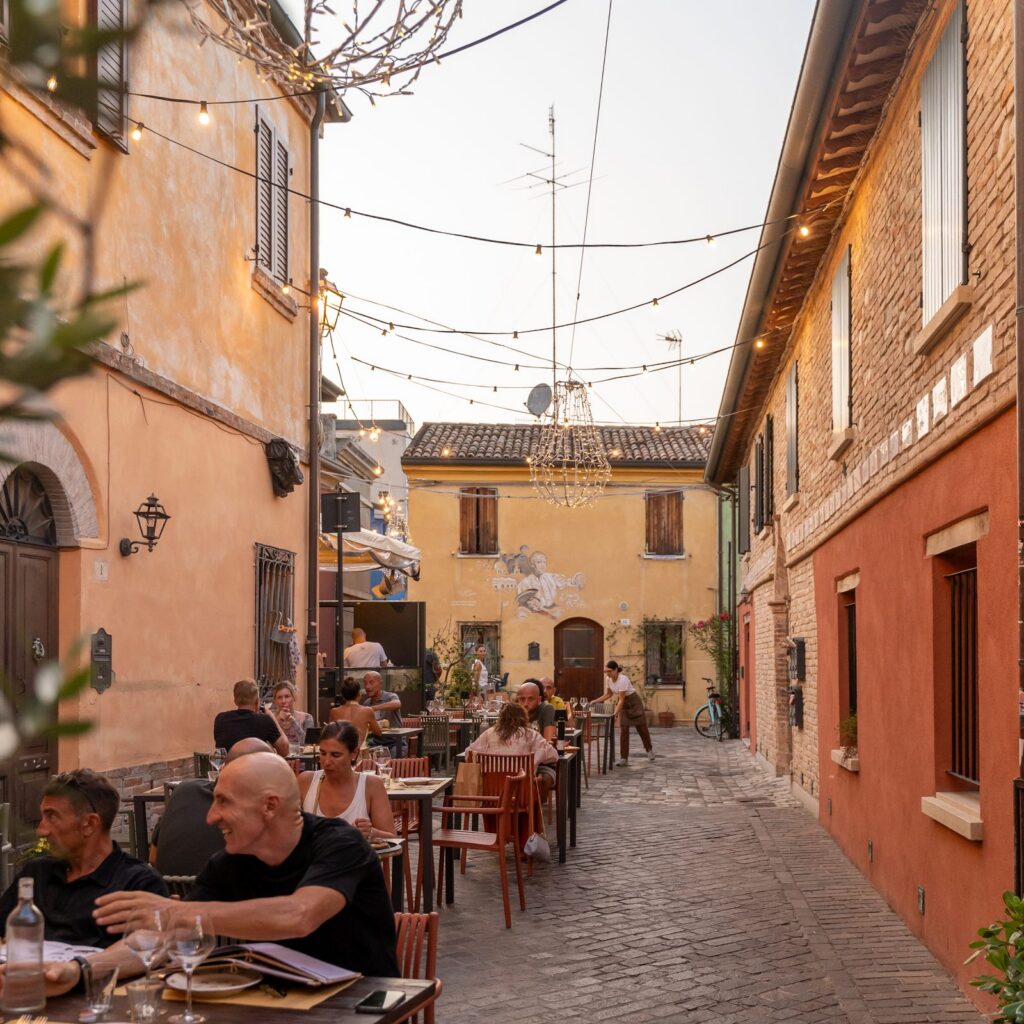 Tavolini all'aperto sotto le luminarie in un vicolo del centro storico di Rimini