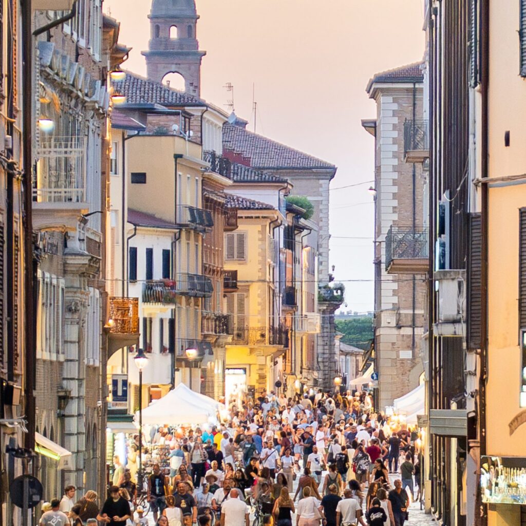 Folla e bancarelle nel corso del centro storico di Rimini al tramonto durante la Shopping Night